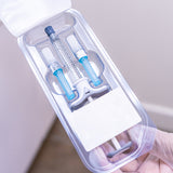 Medical provider holding carton with a 1mL Juvederm Ultra Plus XC syringe, and two needles included.